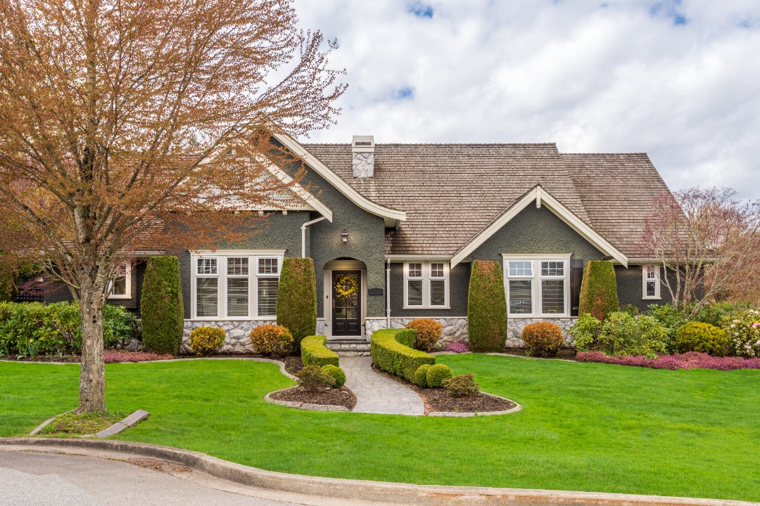 A perfectly mowed lawn with shaped bushes to help increase home value and aesthetics.